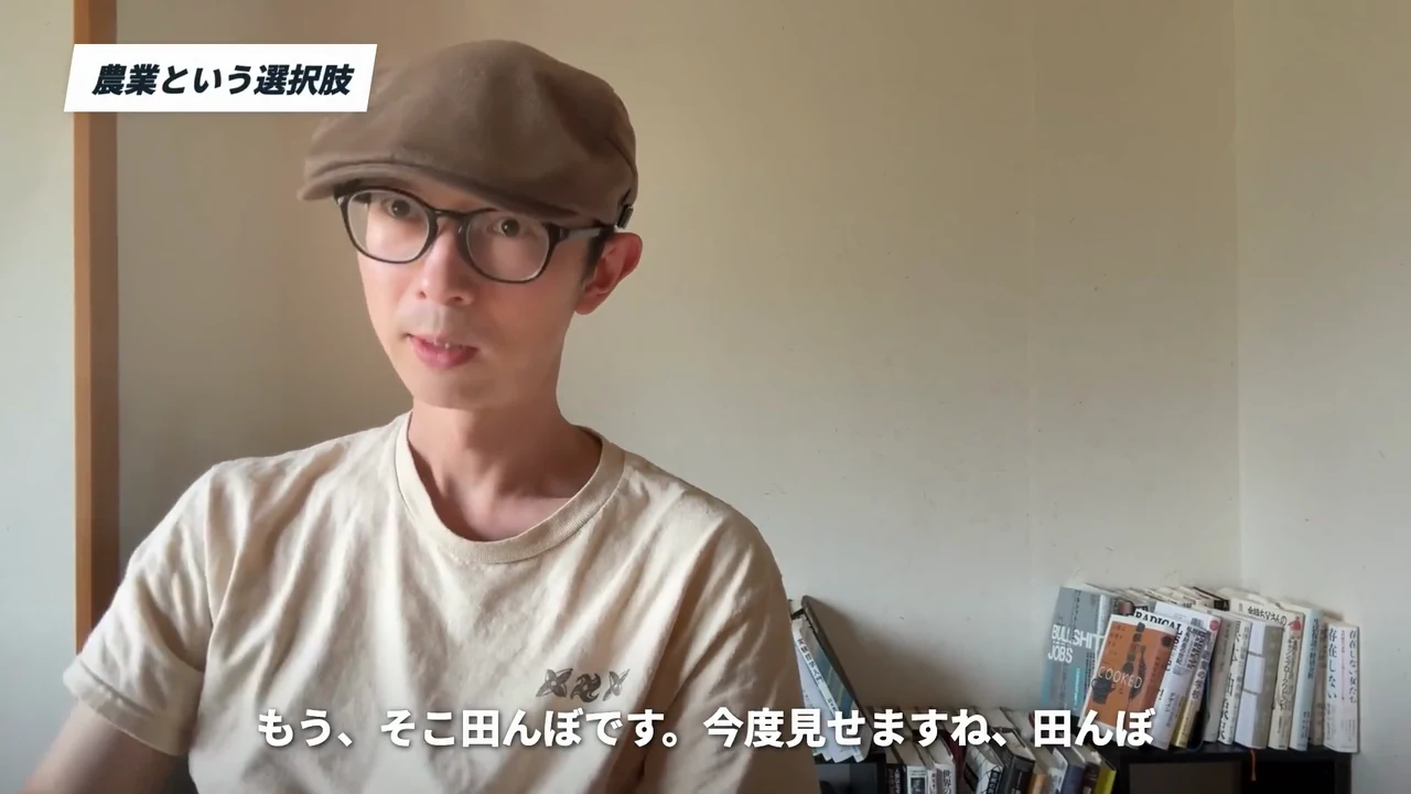 動画キャプチャ: 帯「農業という選択肢」と字幕「もう、そこ田んぼです。今度見せますね、田んぼ」の場面