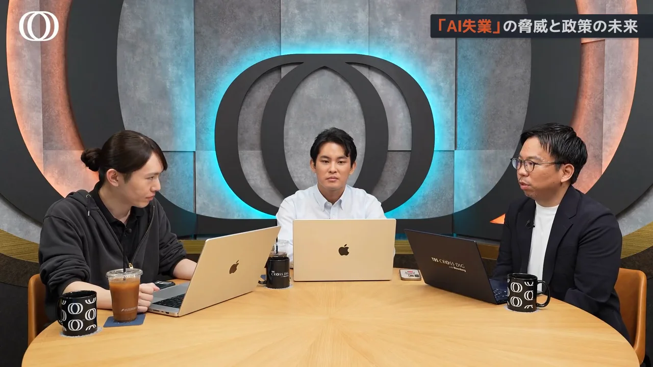 動画キャプチャ: AI失業の脅威と政策の未来のテロップが出た、丸テーブルで右の人が話す場面（55:03頃）