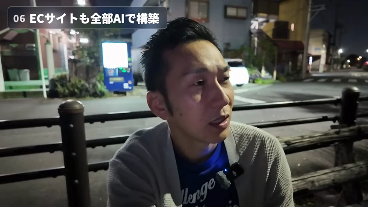 動画キャプチャ: 「ECサイトも全部AIで構築」のチャプターで、三森さんが柵のそばで話している場面（6:12頃）