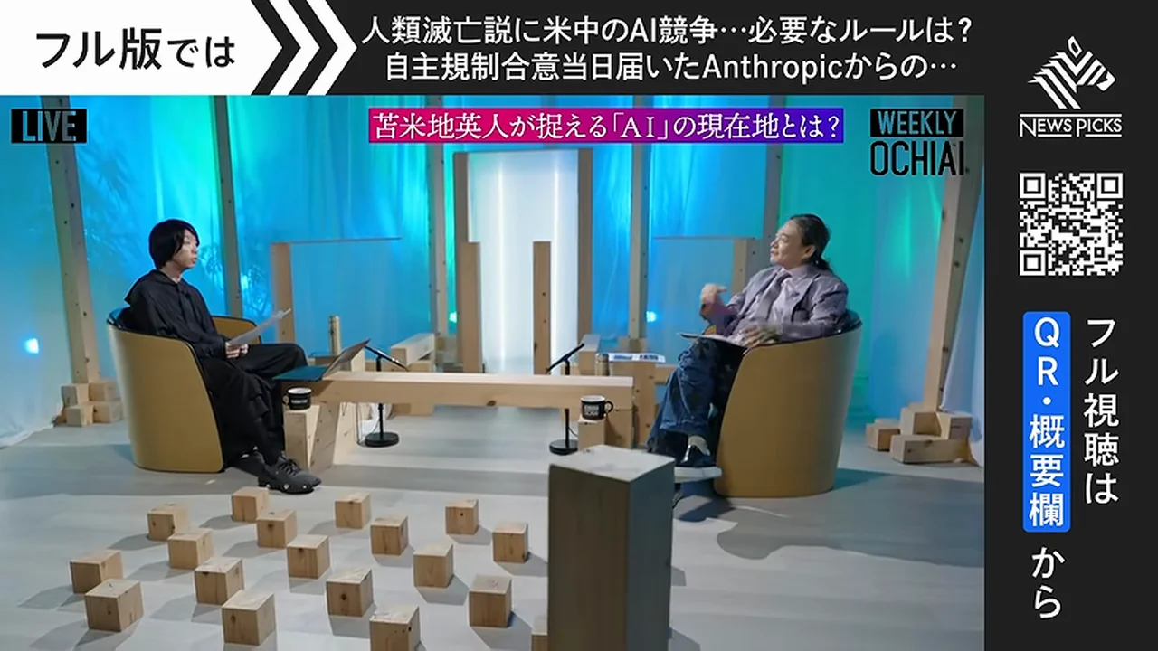 動画キャプチャ: スタジオ全景。二人が向かい合って座り、床に木のブロックが並ぶ場面（12:15頃）