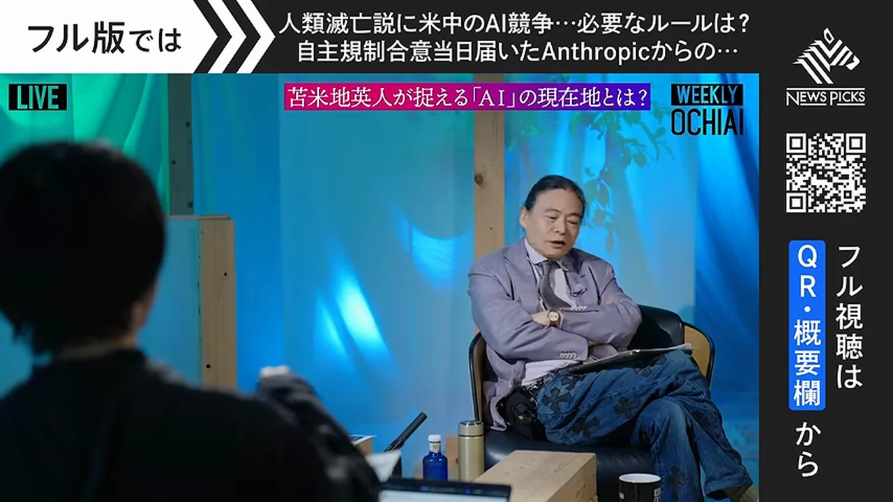 動画キャプチャ: 苫米地さんが椅子に座って話し、手前に聞き手の後ろ姿が映る場面（12:45頃）