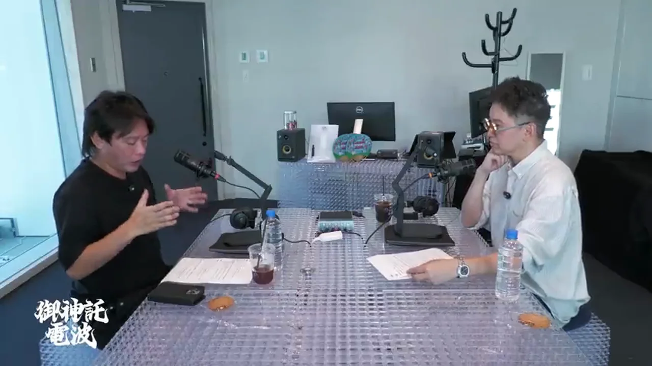 動画キャプチャ: 箕輪さんが手を広げて話し、けんすうさんが手を顎に当てて聞いている場面（18:30頃）