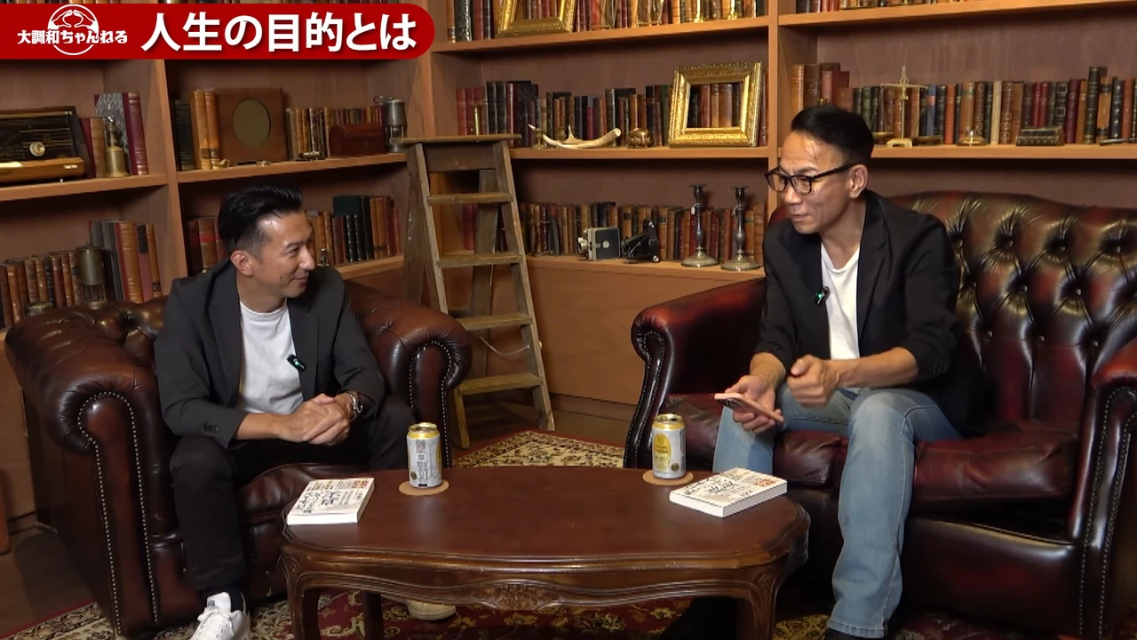 動画の画面。長嶋さんがスマホを手に、人生をゲームにたとえて話している場面