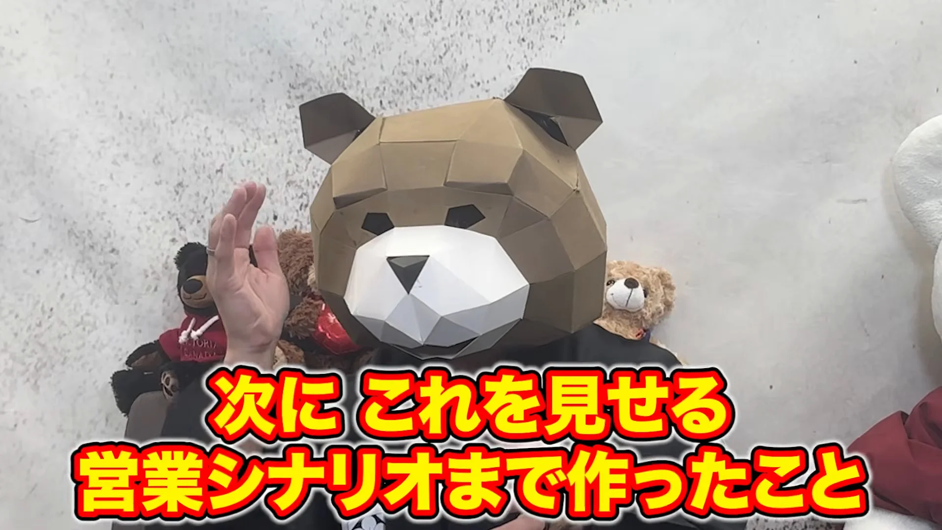 クマのマスクをかぶったりゅう先生が、手を合わせるようにして話している動画の場面。下の字幕に、次に これを見せる 営業シナリオまで作ったこと、と出ている