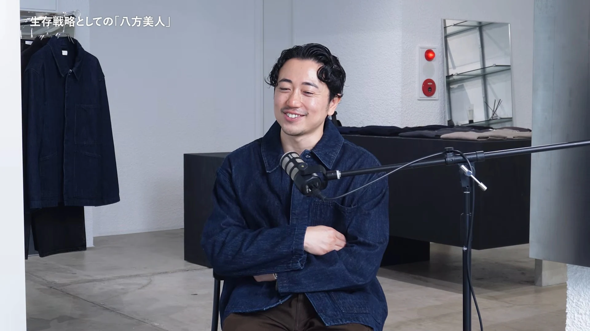 画面左上に生存戦略としての八方美人と出て、デニムジャケットのゲストが笑顔で腕を組んで座る動画の場面
