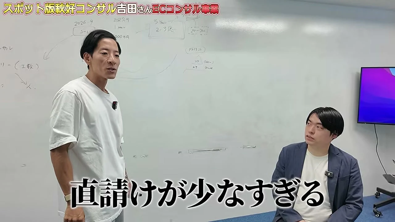 動画の画面。ホワイトボードの前に立つ白いTシャツの男性が話し、右に座る紺のジャケットの男性が聞いている。字幕に、直請けが少なすぎる、と出ている場面