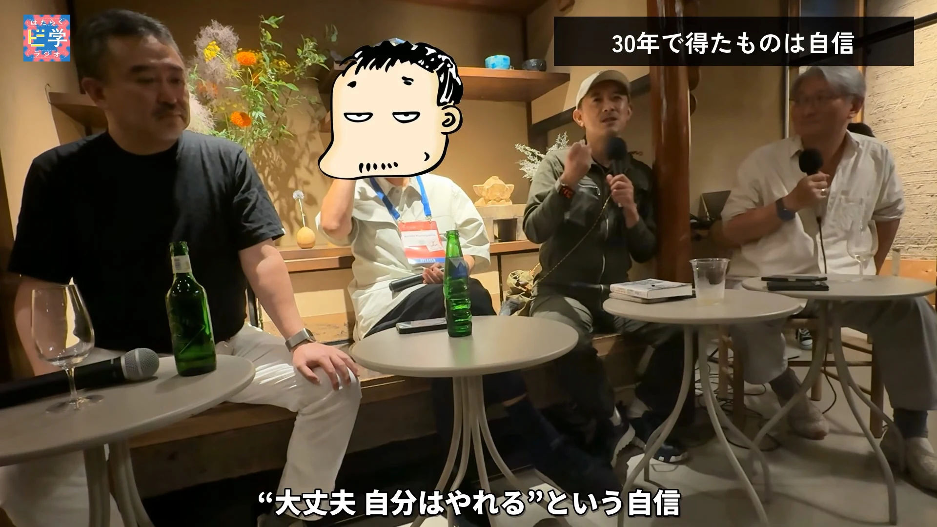 動画の画面。キャップの人がマイクを持って話し、左に黒い服の人、右に白髪の人が座っている。右上のテロップは30年で得たものは自信、下のテロップは大丈夫、自分はやれるという自信という内容