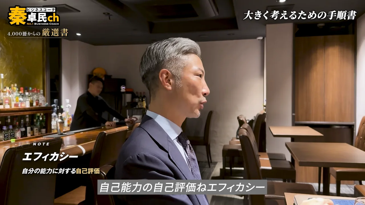 動画の画面。横顔で話す秦卓民さんの左下に、NOTE、エフィカシー、自分の能力に対する自己評価、と注釈が出ている。右上に、大きく考えるための手順書、と出ている。