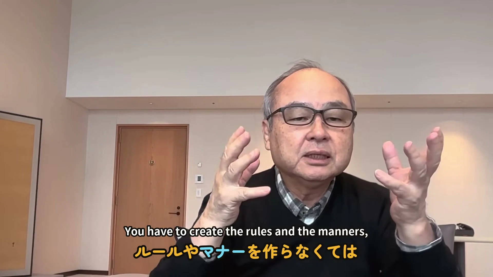 動画キャプチャ: 字幕にルールやマナーを作らなくてはと出ている。話し手が両手を広げて話している(5:22頃)