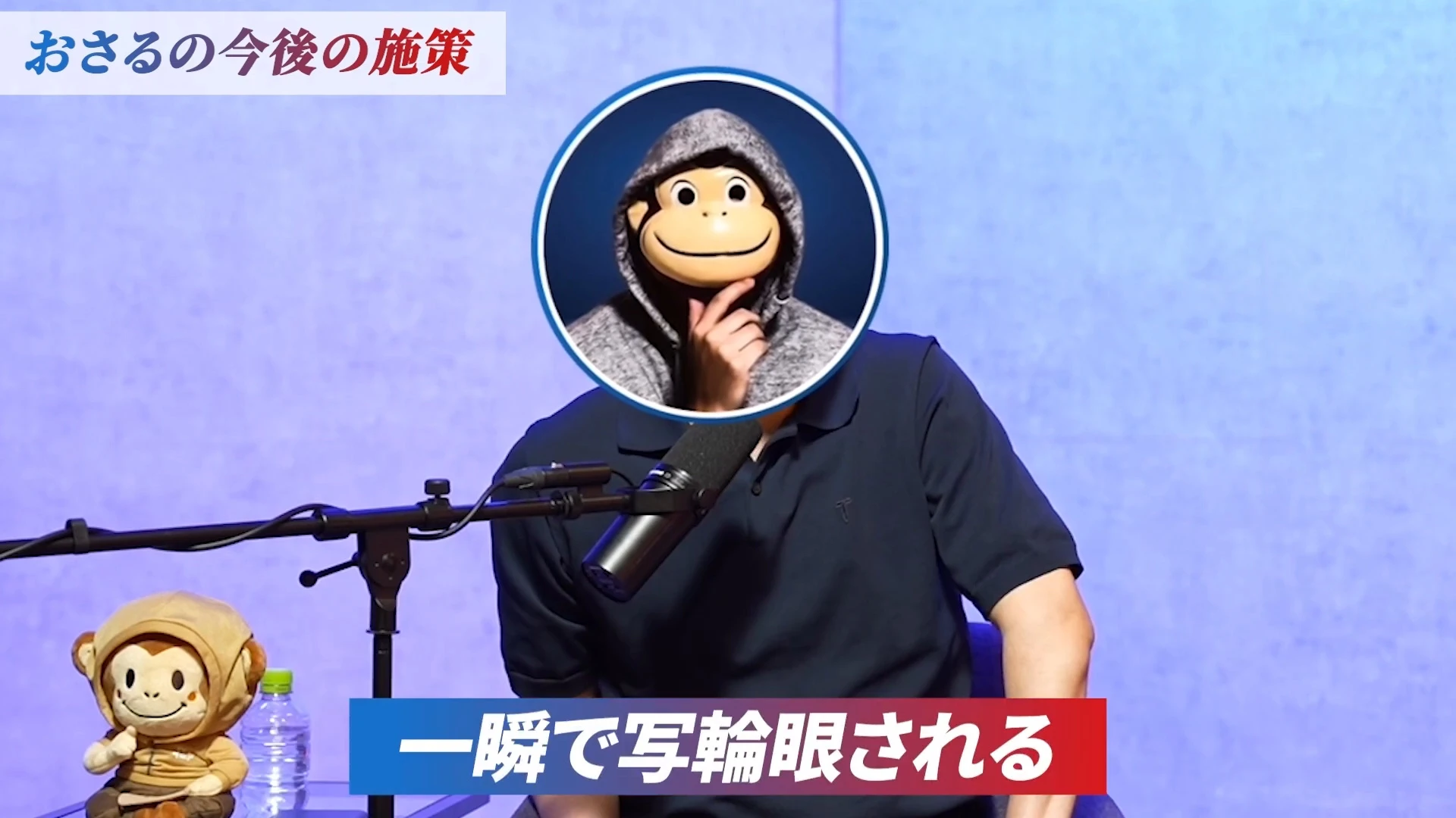 動画の画面。サルのお面のおさるさんが椅子に座り、下に字幕「一瞬で写輪眼される」。左上に「おさるの今後の施策」の帯