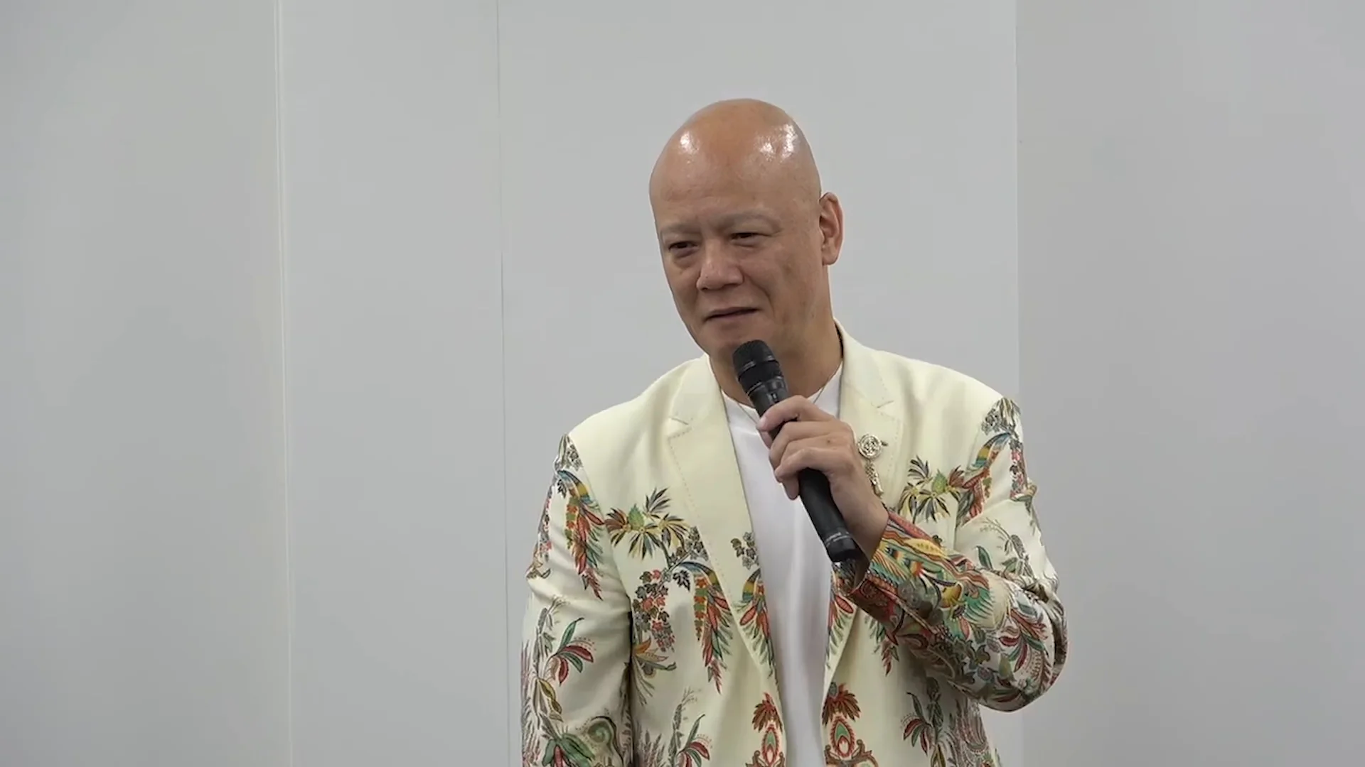 鴨頭嘉人さんが笑顔でマイクを持ち、表現力の実演で声の使い方を見せる講義の場面