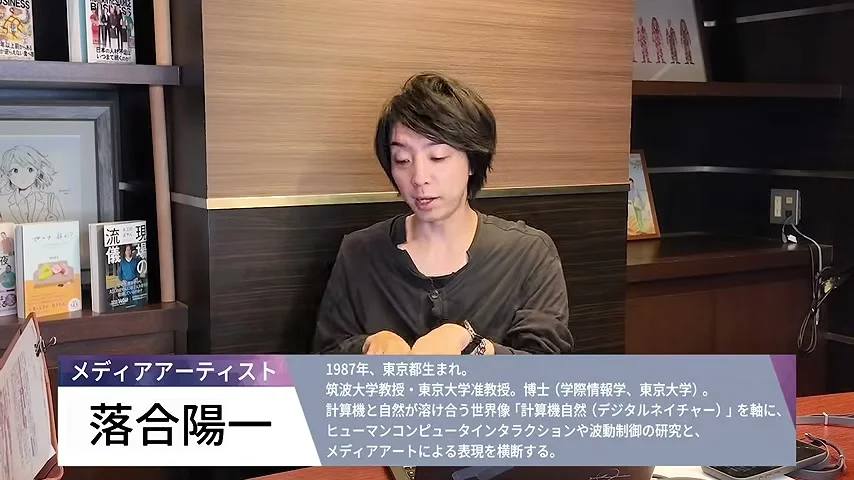 動画の画面。書棚の前に座る落合陽一さんと、画面下に出る落合陽一さんの紹介テロップ