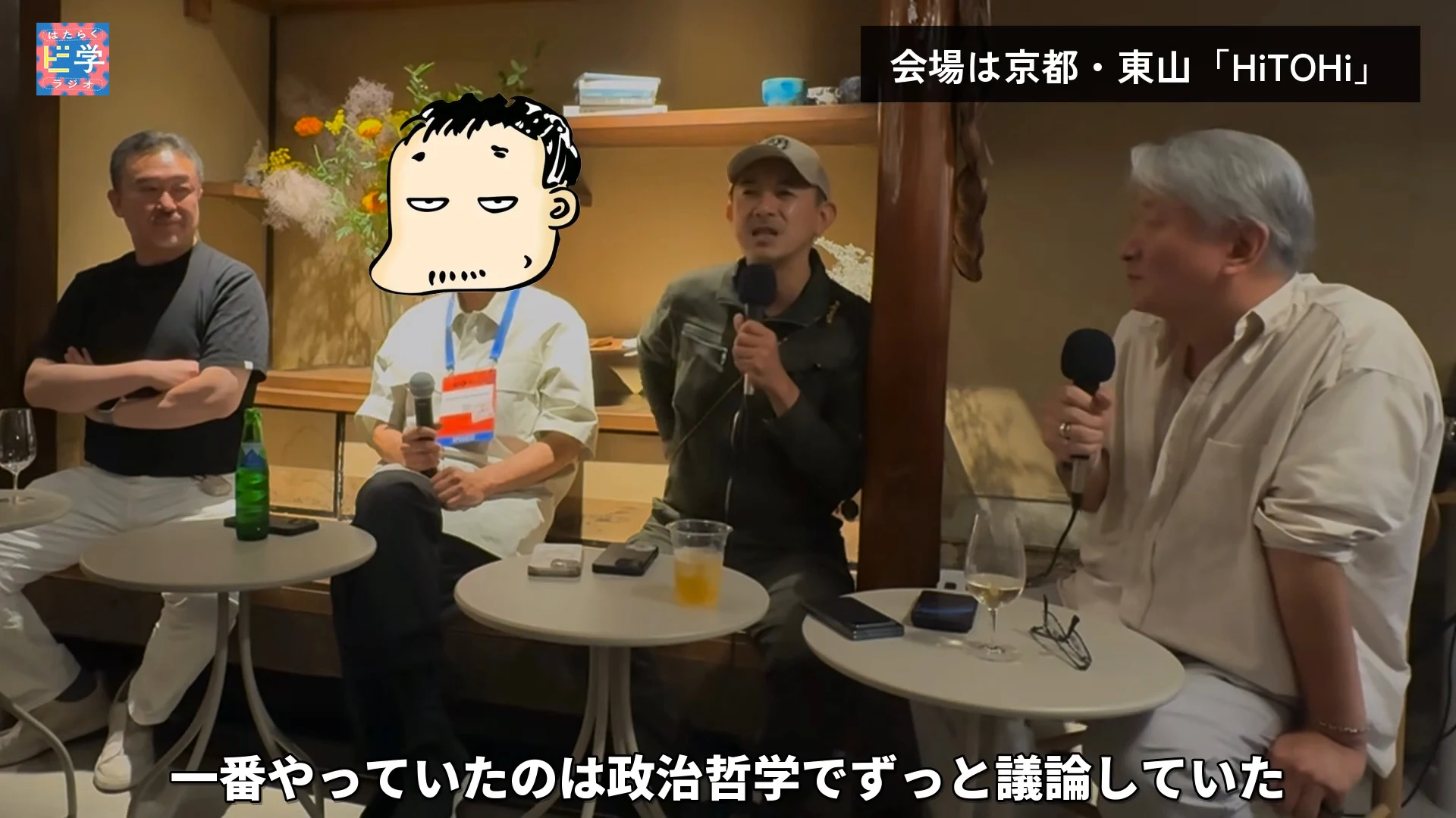 動画の画面。京都・東山の会場で、四人が並んで座っている。顔をイラストで隠した司会の右でキャップの人がマイクを持って話し、右上のテロップは会場の紹介、下のテロップは政治哲学でずっと議論していたという内容