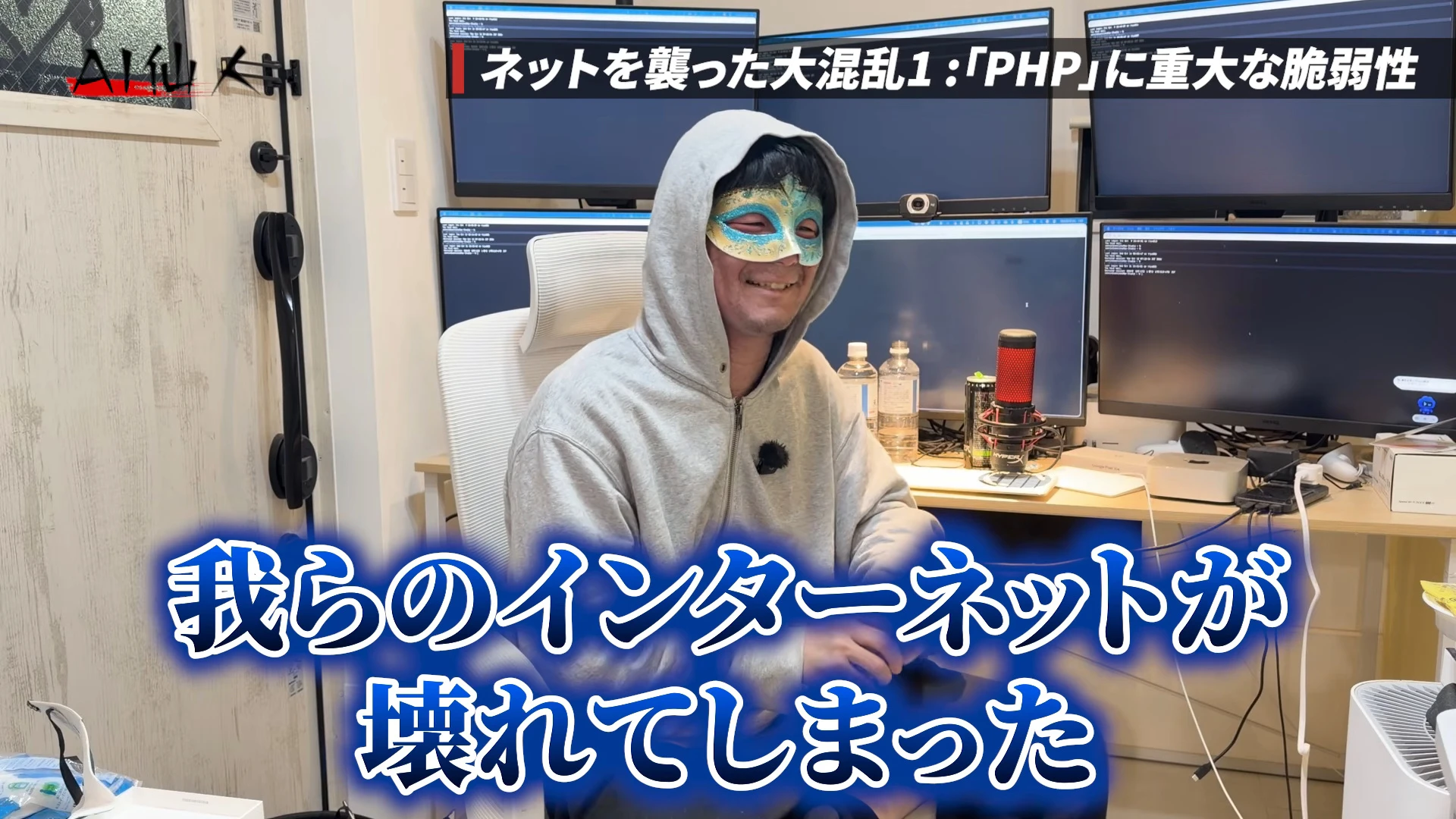 動画キャプチャ。右上にネットを襲った大混乱1、PHPに重大な脆弱性の帯、下に大きく我らのインターネットが壊れてしまったの字幕が出て、仮面とグレーのパーカー姿の仙人さんが、モニターの並ぶ部屋で笑って座る動画の場面