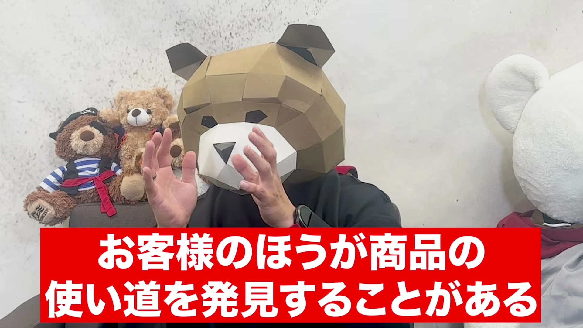 動画の画面。熊の被り物をした話し手が両手を上げて話し、画面下の赤い帯に、お客様のほうが商品の使い道を発見することがある、と出ている。