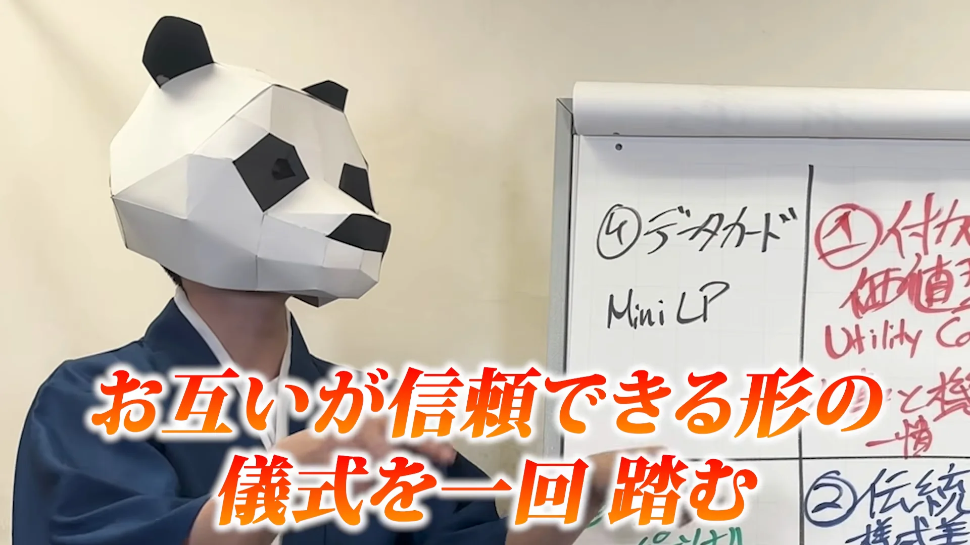 動画の画面。パンダの面の人が名刺を渡す手つきで話し、字幕に「お互いが信頼できる形の儀式を一回踏む」と出る。ボードには「データカード」「付加価値型」「伝統」の文字が見える