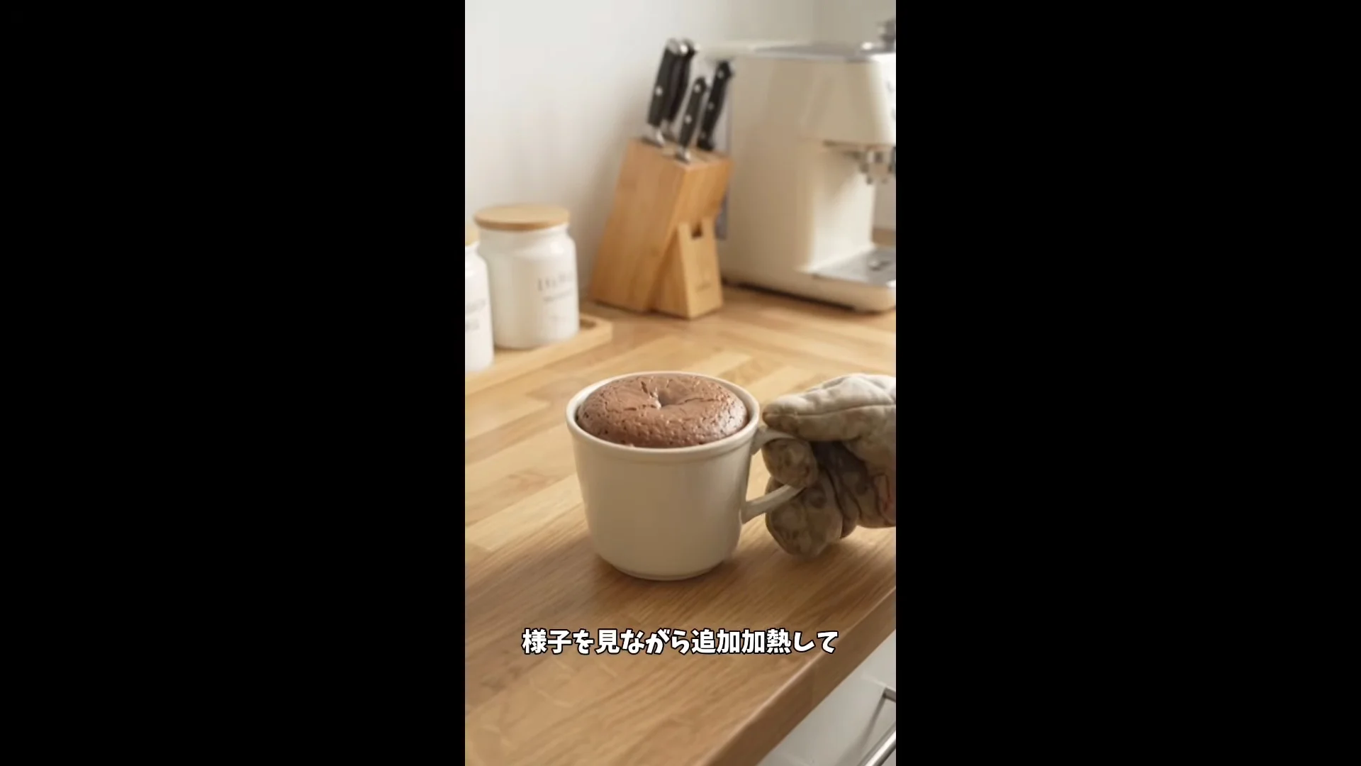 動画の画面。AIで作ったマグカップのケーキの縦動画が流れ、下に「様子を見ながら追加加熱して」の字幕が出ている