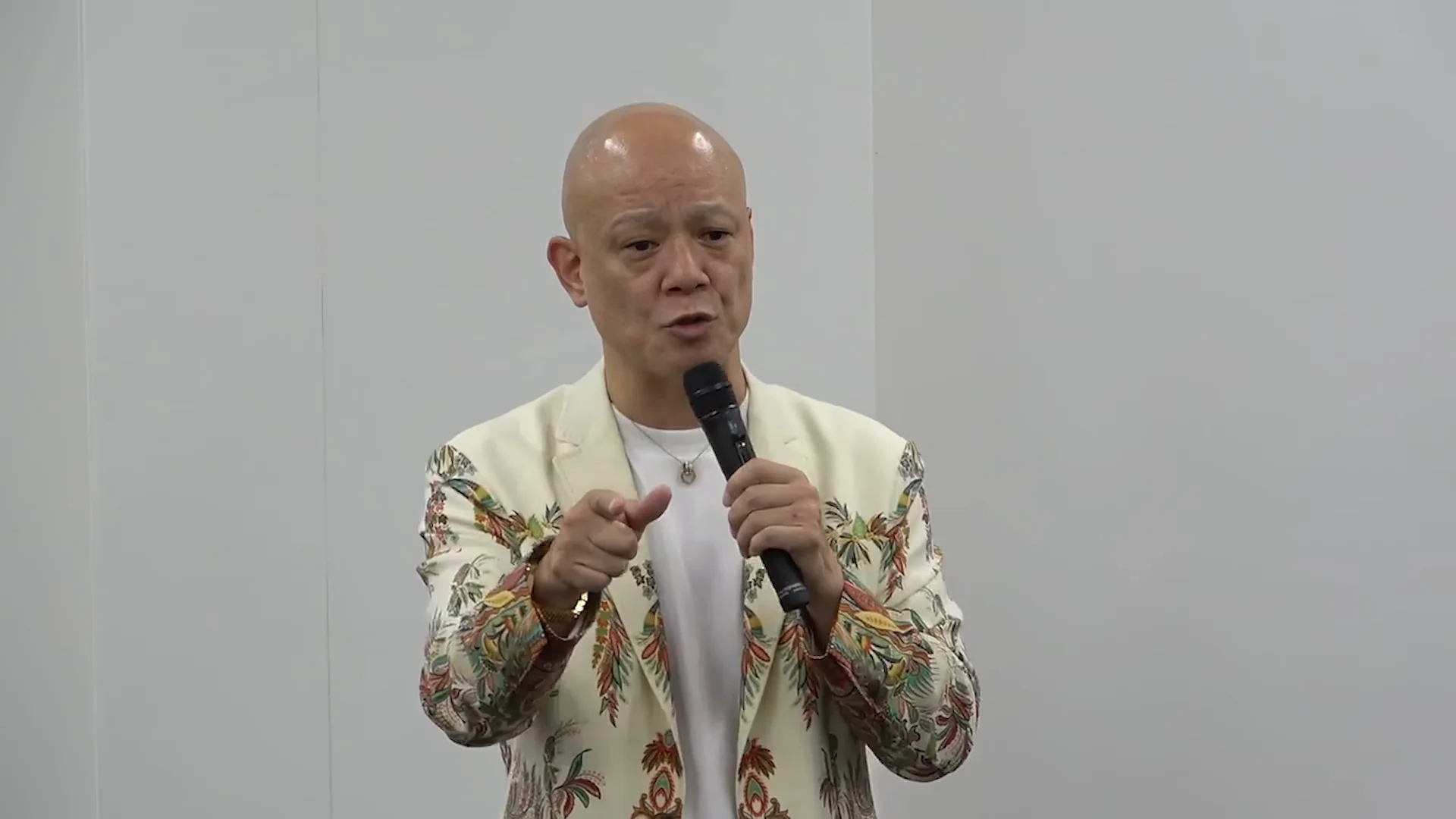 鴨頭嘉人さんがカメラに向かって指をさし、体験の例を挙げて語る講義の場面