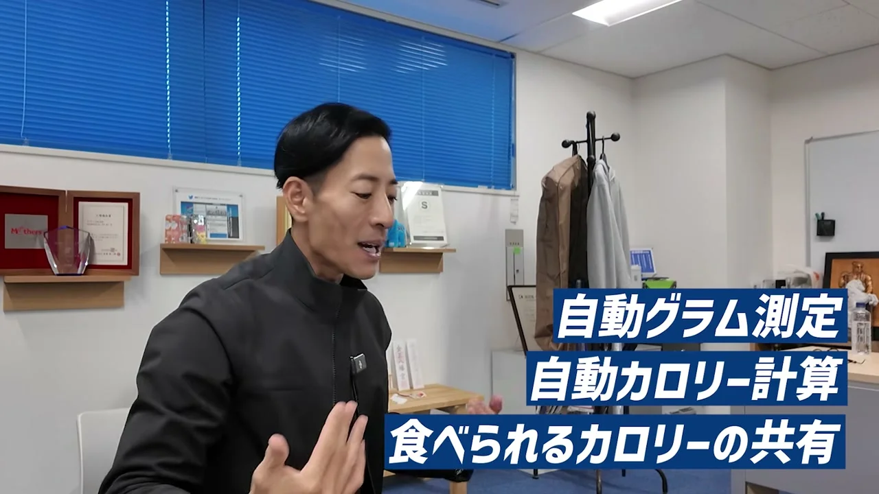 動画キャプチャ: テロップに、自動グラム測定、自動カロリー計算、食べられるカロリーの共有、と出る場面(1:22頃)