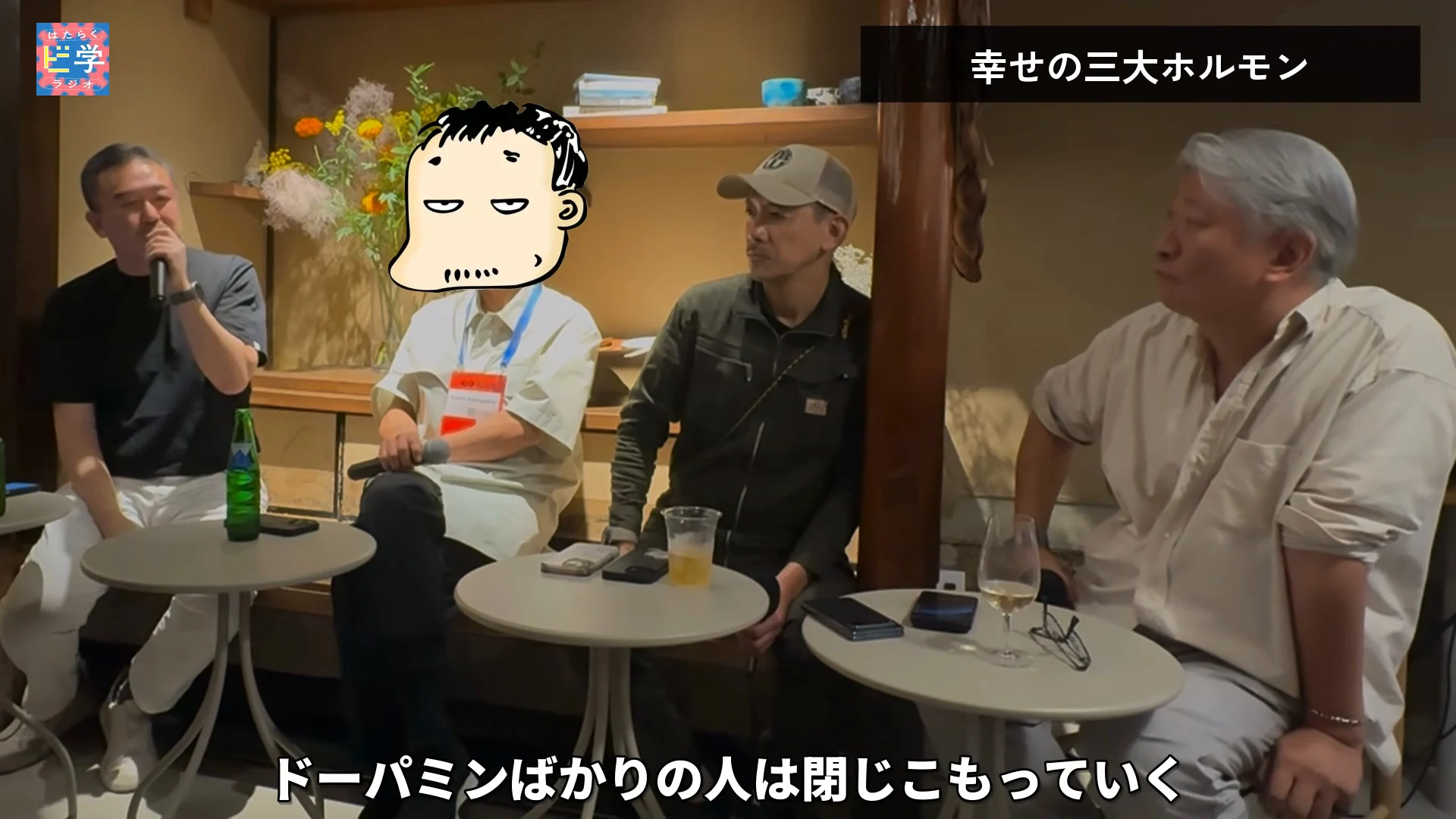 動画の画面。黒い服の人がマイクを口に当てて話し、右の白髪の人が左を向いて聞いている。右上のテロップは幸せの三大ホルモン、下のテロップはドーパミンばかりの人は閉じこもっていくという内容