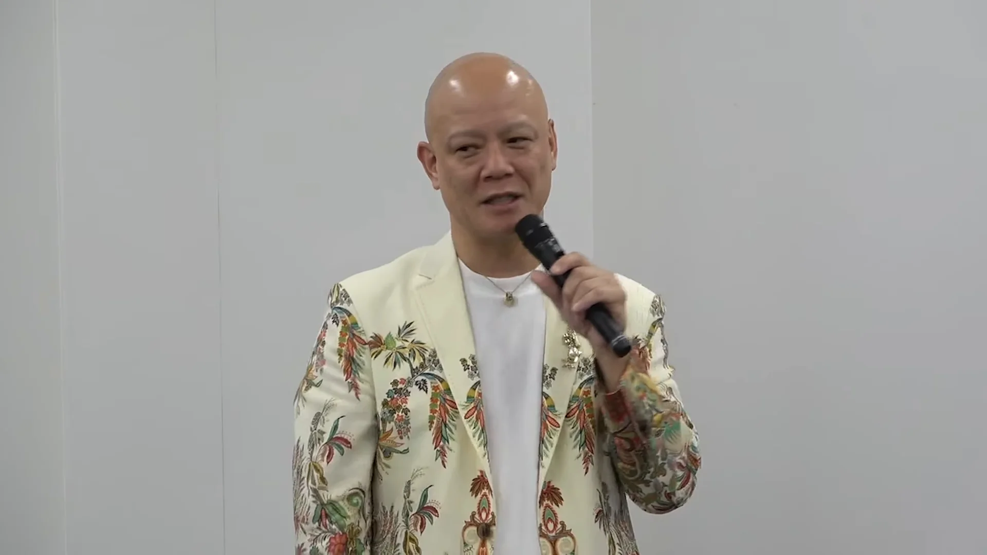 鴨頭嘉人さんが笑顔でマイクを持ち、足りないのは希望だと語る講義の場面
