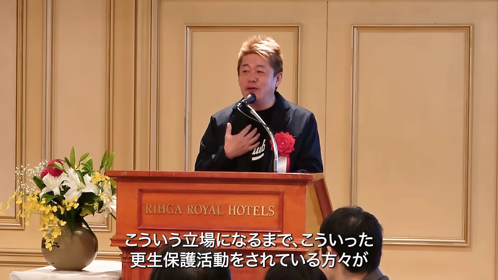 動画の場面: 更新会の集いでスピーチをする堀江貴文さん(2分55秒ごろ)