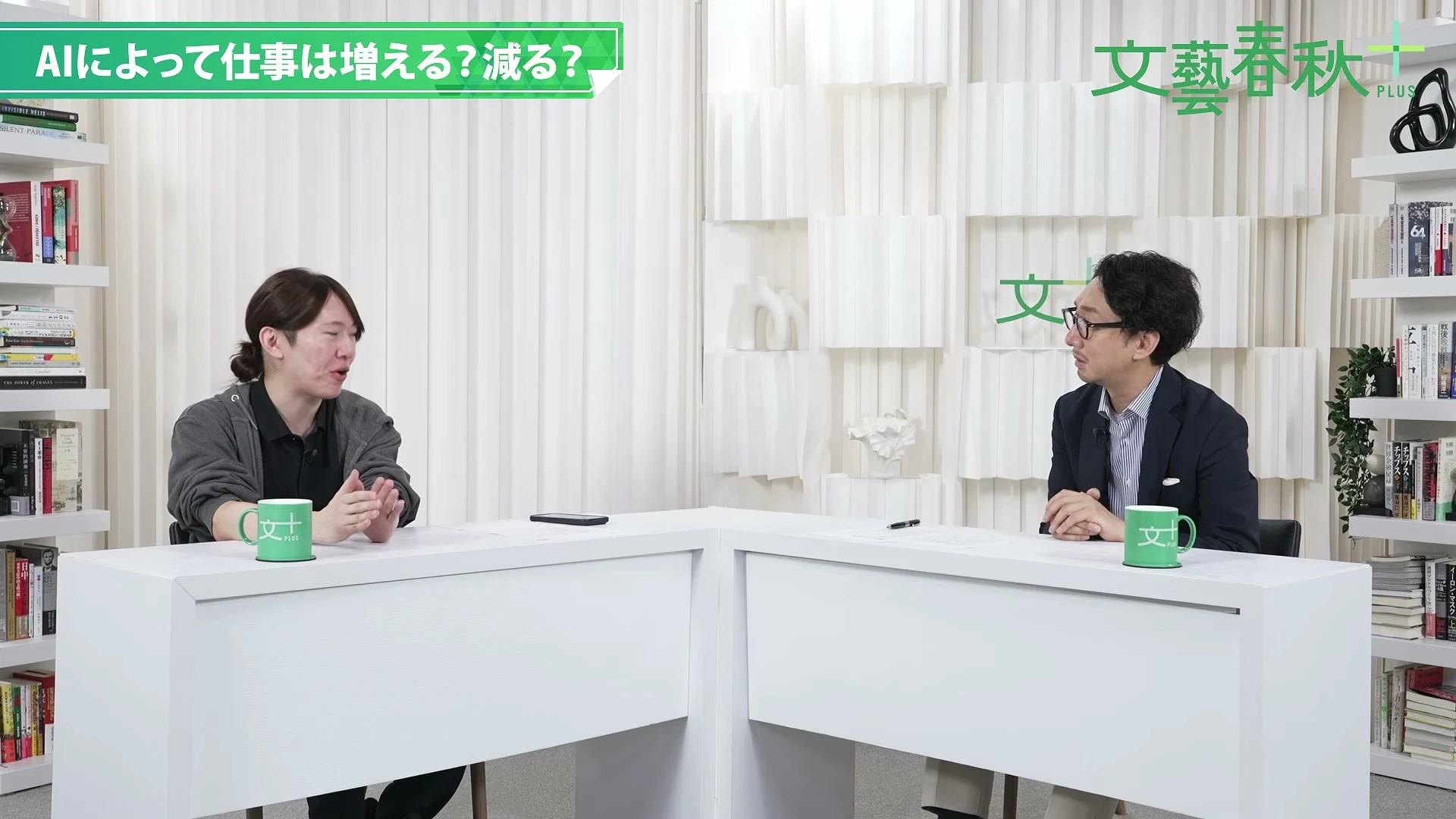 動画キャプチャ: 「AIによって仕事は増える?減る?」の章で、スタジオで向かい合って話す安野貴博さんと聞き手の村井弦さん(12:08頃)