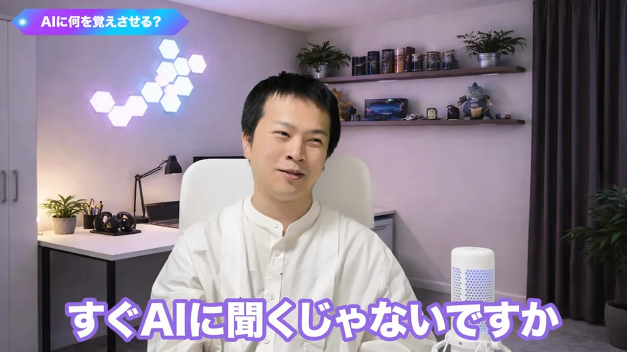 動画キャプチャ: 「AIに何を覚えさせる?」の見出しのもと、飯塚さんが「すぐAIに聞くじゃないですか」と笑顔で話す画面(4:26頃)