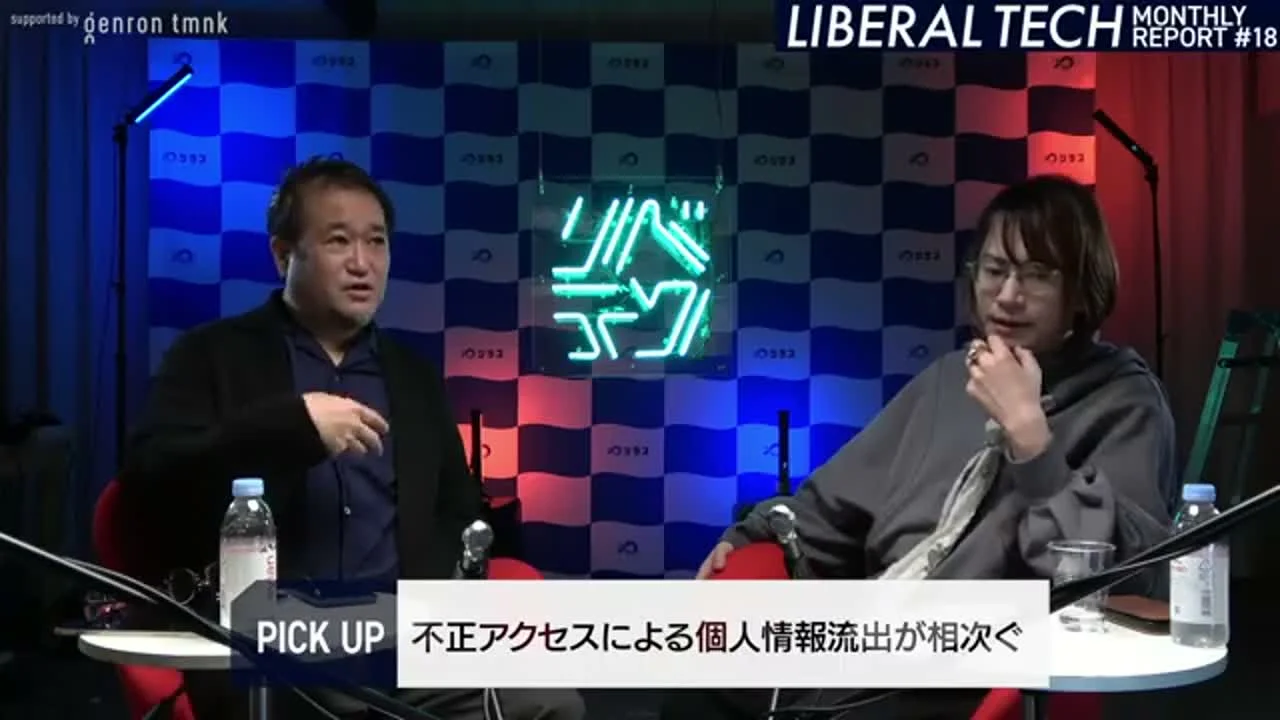 動画キャプチャ: スタジオで二人の出演者が向かい合う全景。画面下に「不正アクセスによる個人情報流出が相次ぐ」の字幕（20:15頃）