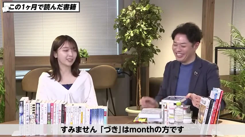 動画キャプチャ: 竹下さんの後ろに紹介本の本棚が並ぶスタジオ（16:01頃）