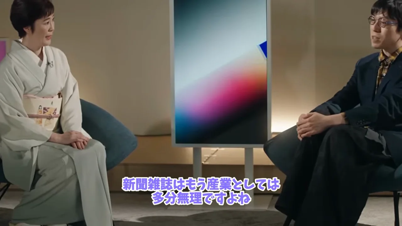 動画キャプチャ: テロップ「新聞雑誌はもう産業としては多分無理ですよね」が出ている場面（0:15頃）