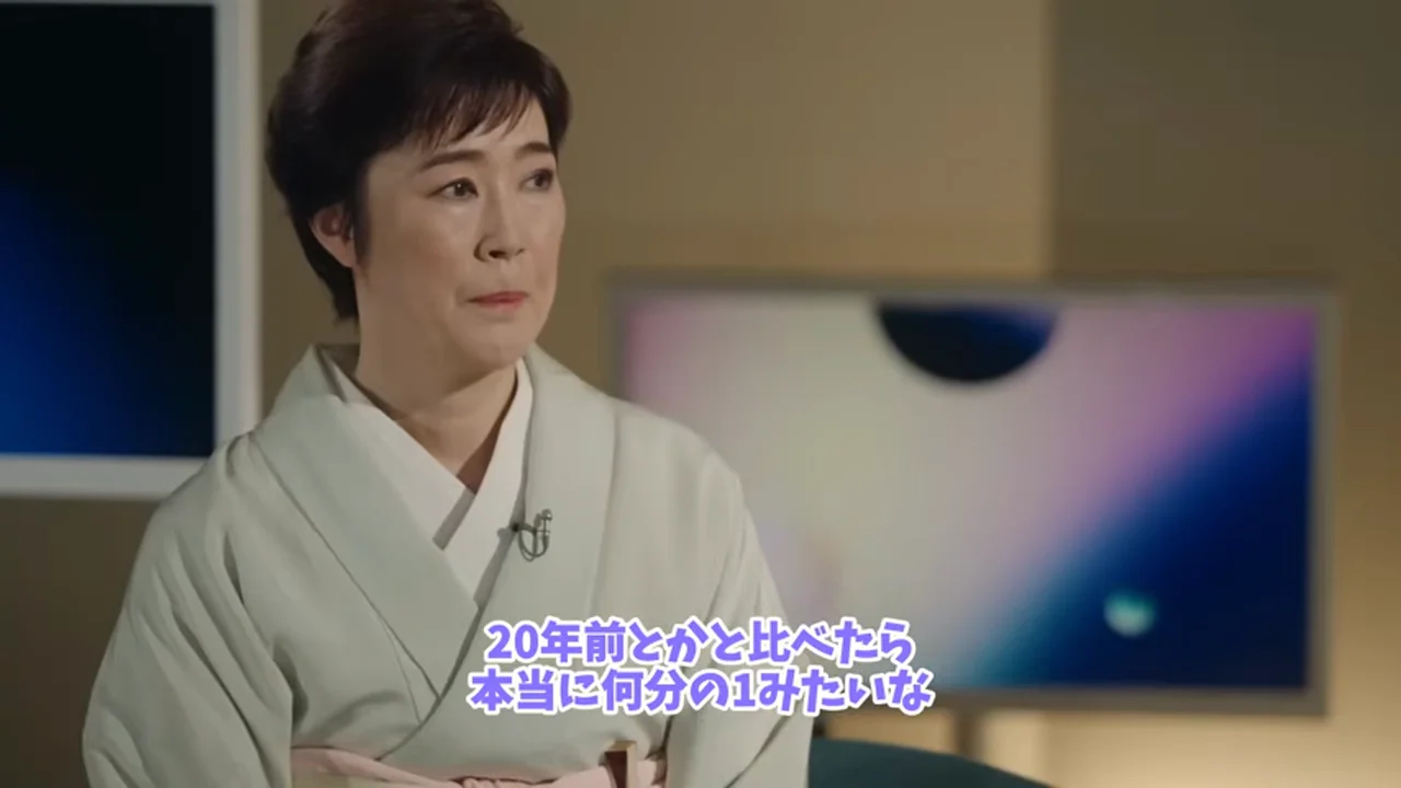 動画キャプチャ: テロップ「20年前とかと比べたら 本当に何分の1みたいな」が出ている場面（0:23頃）