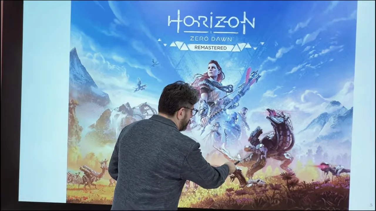 動画キャプチャ: ゲーム『Horizon Zero Dawn』のポスターを指しながら、AIとロボットの物語を話す場面(2:30頃)