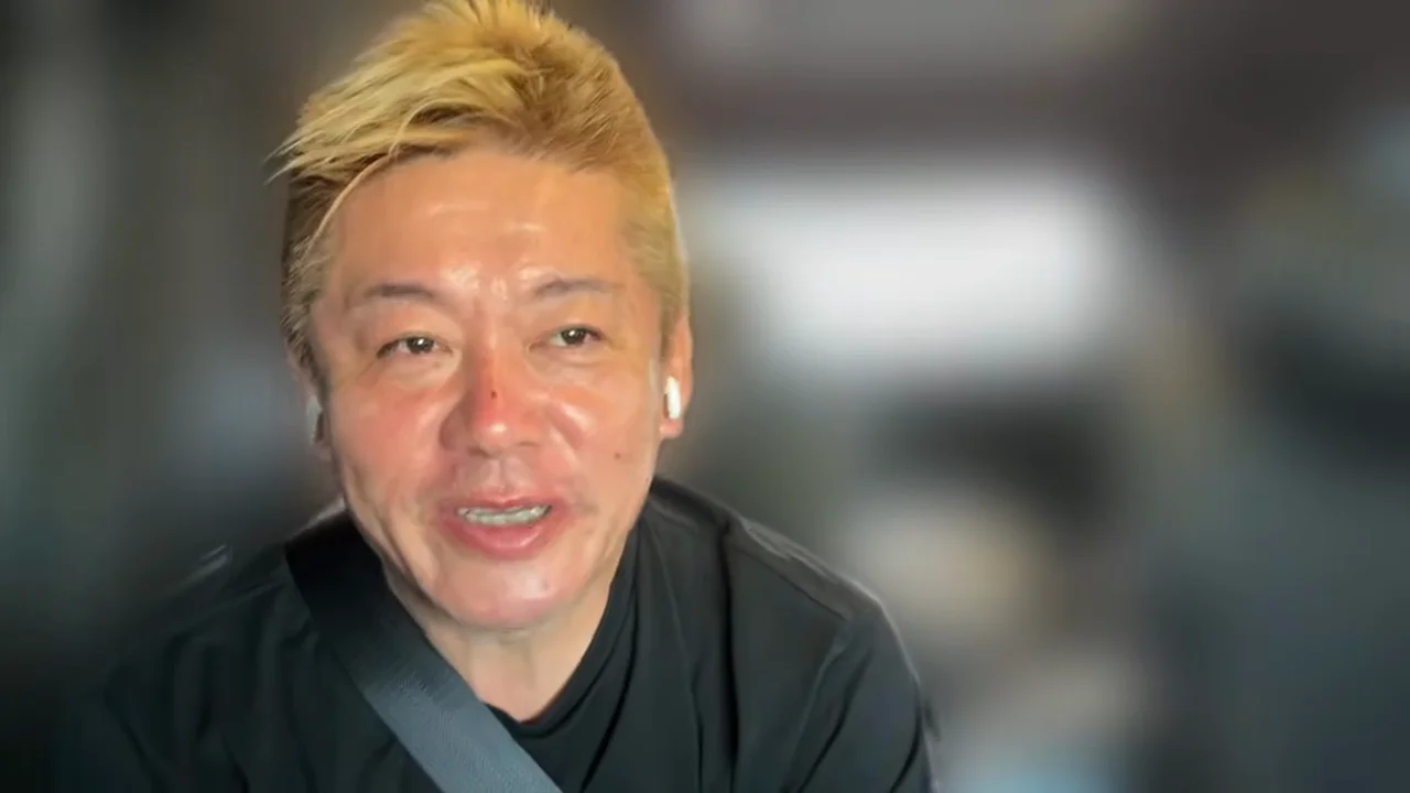 動画キャプチャ: 堀江さんが、Xのコメント欄の批判について話す場面（4:59頃）
