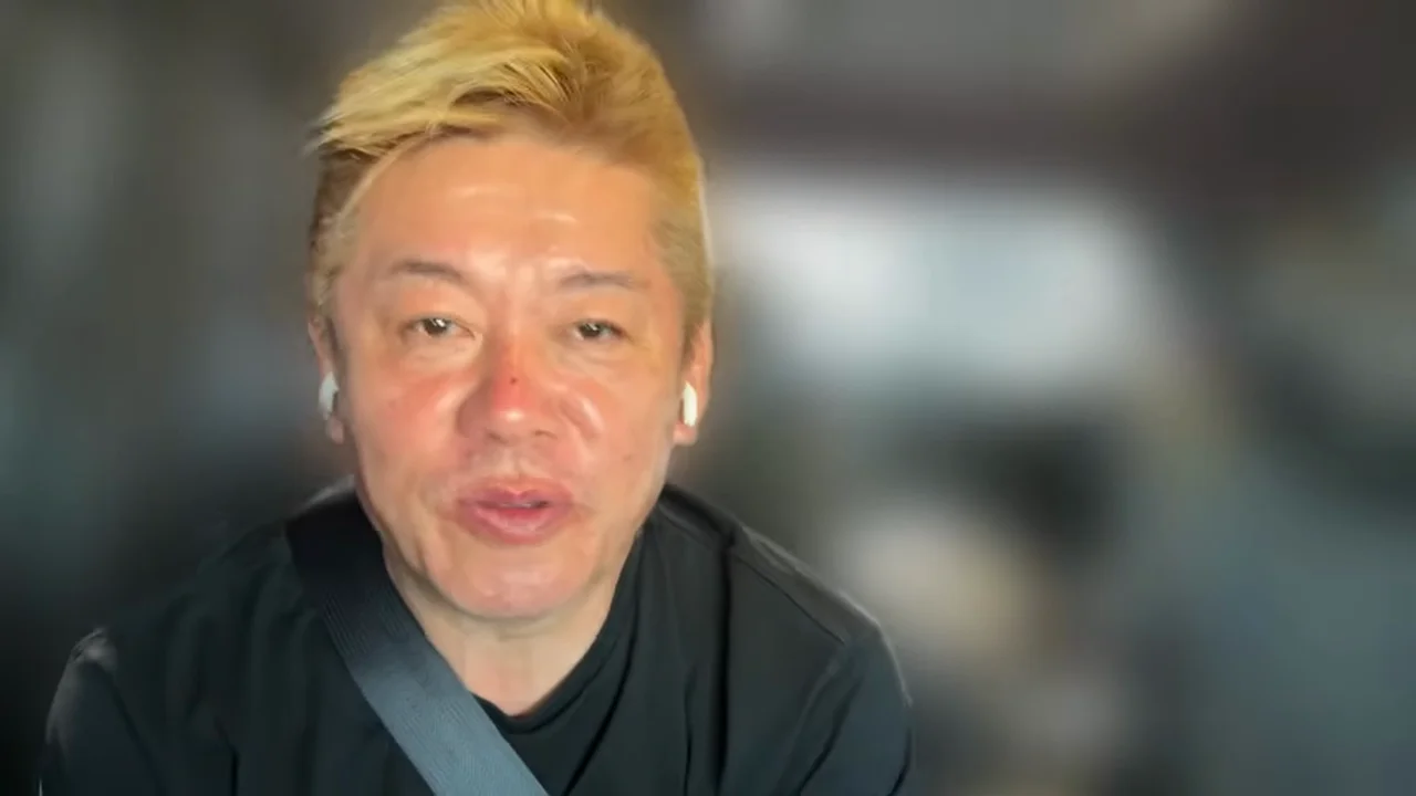 動画キャプチャ: 堀江さんが、AIを巨大な図書館にたとえて反論する場面（5:50頃）