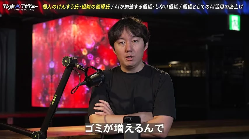 動画キャプチャ: 対談の1場面。腕を組んで話す場面で、画面の字幕は「ゴミが増えるんで」（8:43頃）