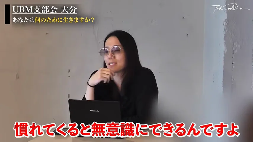 動画キャプチャ: 「慣れてくると無意識にできるんですよ」のテロップが出て、講話をしている場面(9:58頃)