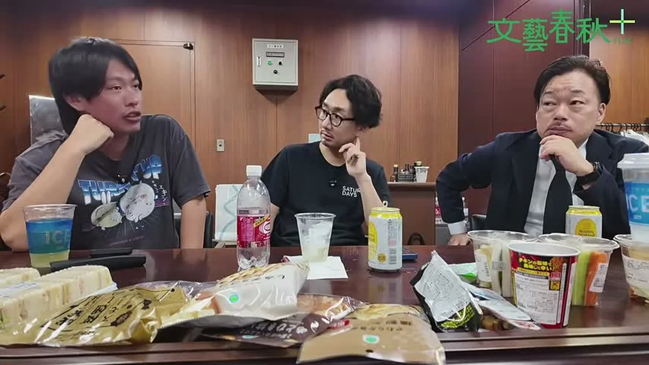 動画キャプチャ: 3人が机で話す場面（1:14:56頃）
