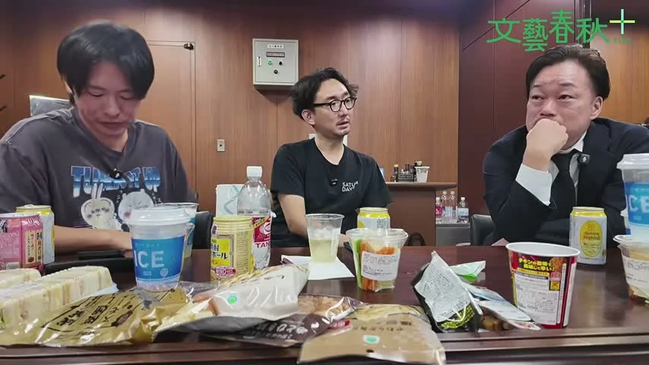動画キャプチャ: 3人が机で話す場面（1:37:03頃）