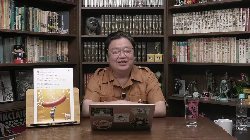 動画キャプチャ: ソーセージの告知のフリップを脇に置いて、岡田さんが話している場面（8:52頃）