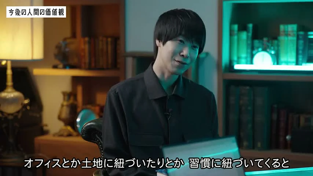 動画キャプチャ: 佐藤さんが、オフィスや土地、習慣に紐づくと実業になると話す場面（1:04:03頃）